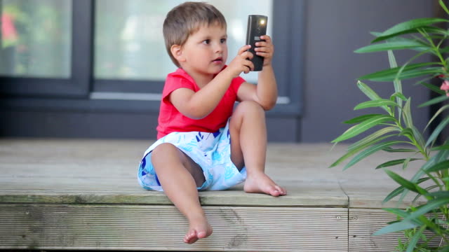 Kleiner-niedlicher-Junge-macht-ein-Foto-mit-Handy