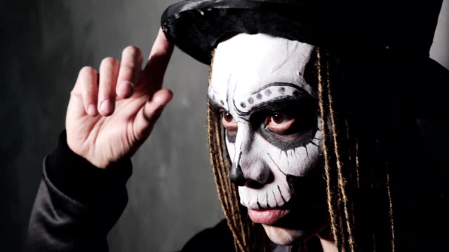Porträt-des-Mannes-in-schwarzem-Hut-mit-beängstigend-Make-up-auf-Gesicht-für-Halloween,-Seitenansicht