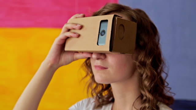 Young-curly-woman-using-Virtual-Reality-Glasses