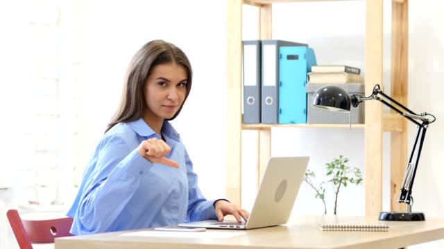 Thumbs-Down-Gesture-by-Woman-at-Her-Work