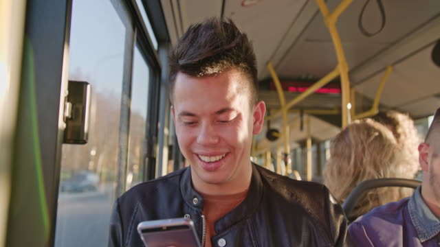 Ein-junger-Mann-mit-einem-Smartphone-auf-dem-Bus