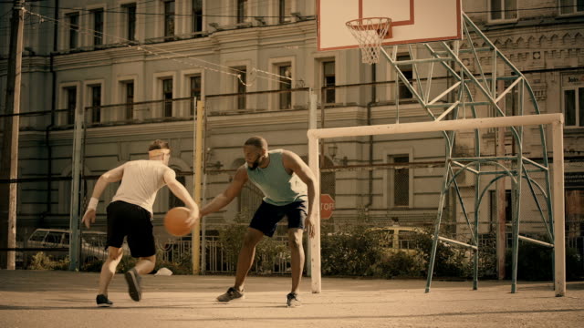 Hombres-blancos-y-negros-jugando-baloncesto,-amigos-activos-teniendo-recuerdos-de-diversión,-buenas