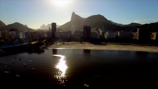 Rio-de-Janeiro-Aerial:-evening-rise-over-sea,-Botafogo-beach-and-buildings-with-Christ-the-Redeemer-in-the-background