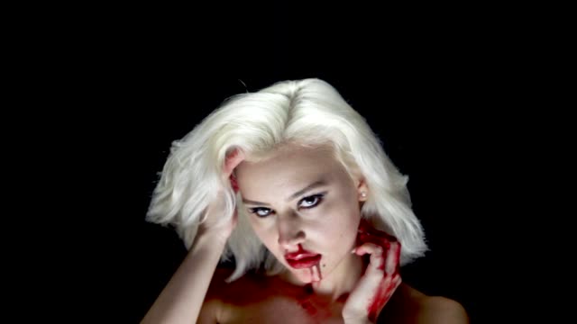 Fashion-blonde-in-harness-with-bloody-hands-and-face