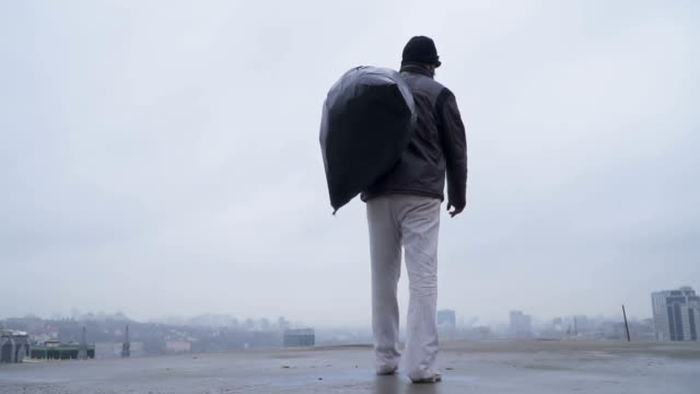 Homeless-with-garbage-bag-at-the-gloomy-city-background