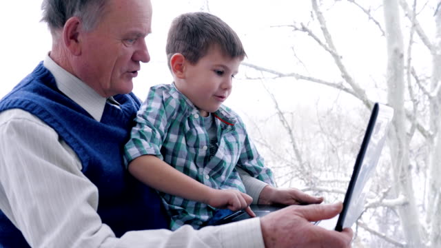 preschool-home-education,-old-man-with-child-with-laptop-in-hand-indoors