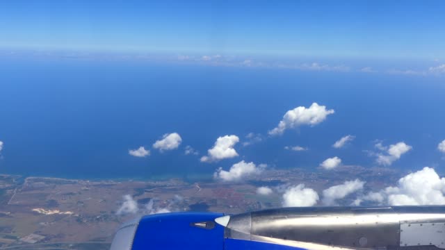 Tiro-POV-de-mar-Caribe-de-avión-asiento-azul-cielo