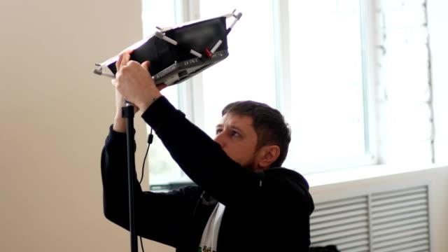Kameramann-stellt-professionelle-Beleuchtung-in-einem-studio