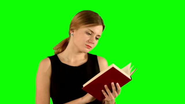 Joven-hermosa-Chica-leyendo-un-libro-en-una-computadora-portátil-en-una-pantalla-verde,-Croma-Clave