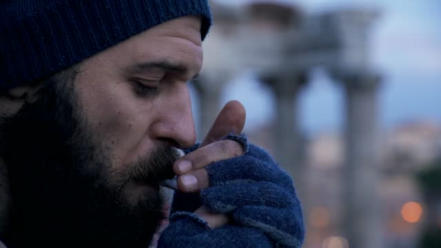 Profil-von-einsamen-Obdachlose-Beleuchtung-Zigarette