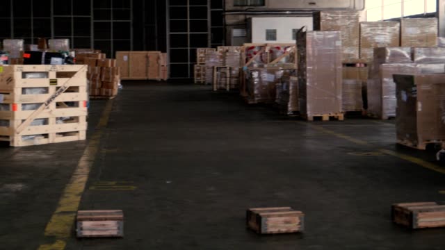 paquetes-y-cajas-en-el-almacén-del-puerto,-dolly