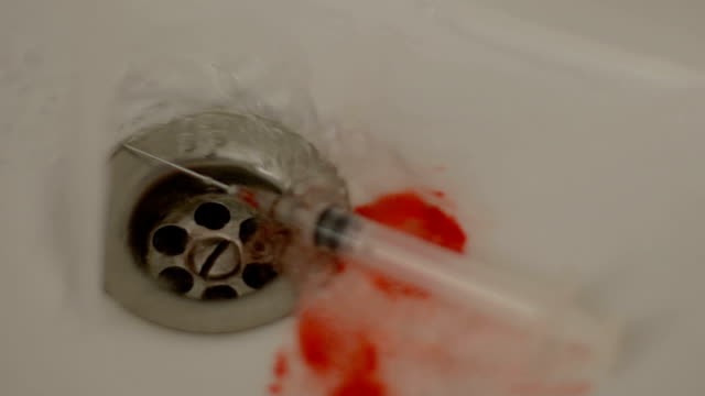 Syringe-in-bloody-sink-washed-by-water,-drug-overdose,-risk-of-HIV-infection
