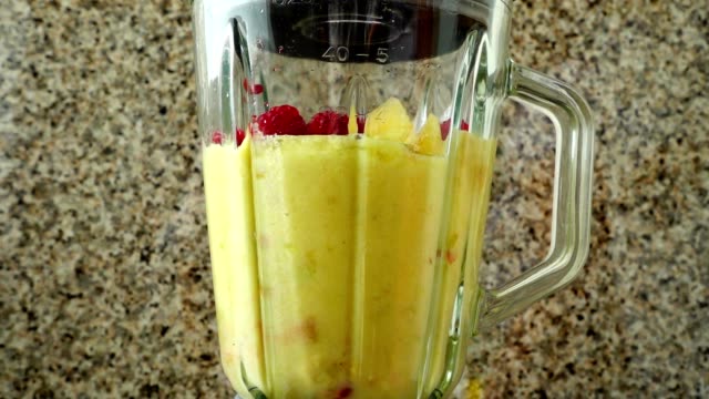 Cocktail-from-pears,-apples,-grapes,-raspberries,-bananas-and-orange-juice.	Slow-motion.
