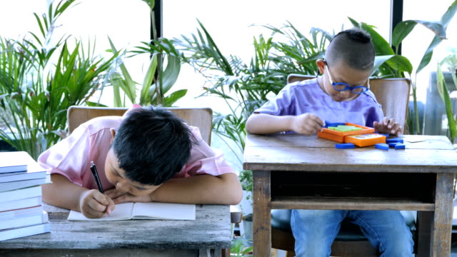 Asiatische-junge-zwei-Leute-mit-dem-Schreiben-von-Hausaufgaben.-Bildungskonzept