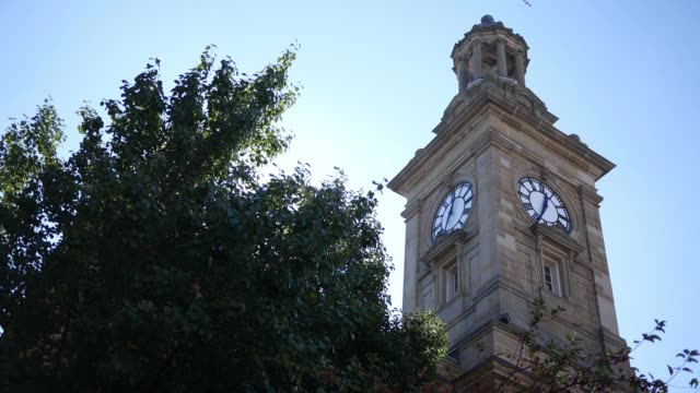 An-establishing-shot-of-a-small-town-clock-tower-ALT