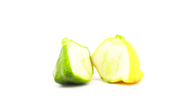 Two-halves-of-green-and-yellow-pattypan-squashes.-Rotating.-Isolated-on-the-white-background.-Close-up.-Macro.