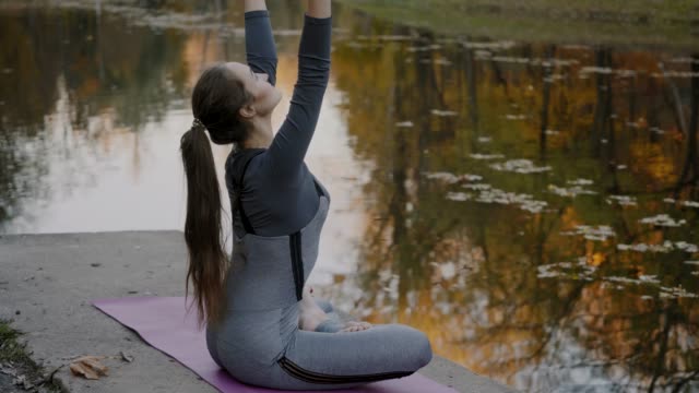 Junge-Frau-praktizieren-Yoga-im-Freien.-Weibliche-meditieren-im-Freien-vor-der-schönen-Herbst-Natur
