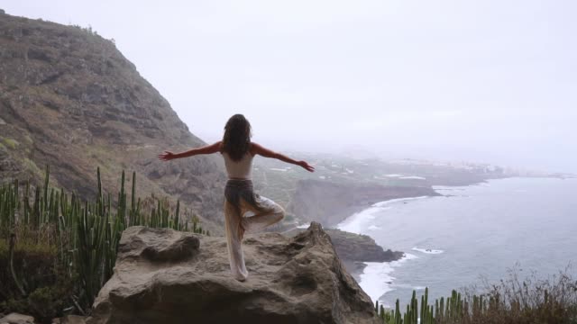 Frau-in-Yoga-Krieger-Pose-auf-den-Ozean,-Strand-und-Felsen-Bergen-meditieren.-Motivation-und-inspirierende-Fit-und-trainieren.-Gesunden-Lebensstil-im-Freien-in-der-Natur,-Fitness-Konzept.