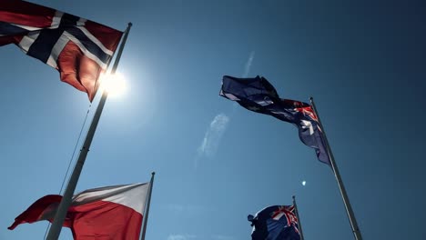 Nationalflaggen-fliegen-vereint-in-Zeitlupe-mit-natürlichen-Sonne-flare