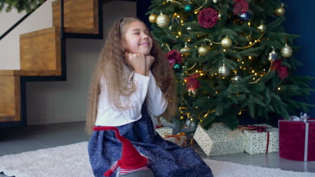 Freudige-verträumte-Mädchen-machen-einen-Wunsch-zu-Weihnachten