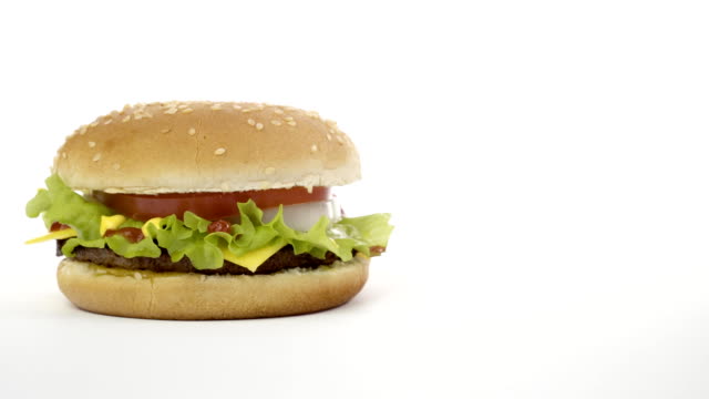 Rotación-de-una-apetitosa-hamburguesa-sobre-un-fondo-blanco