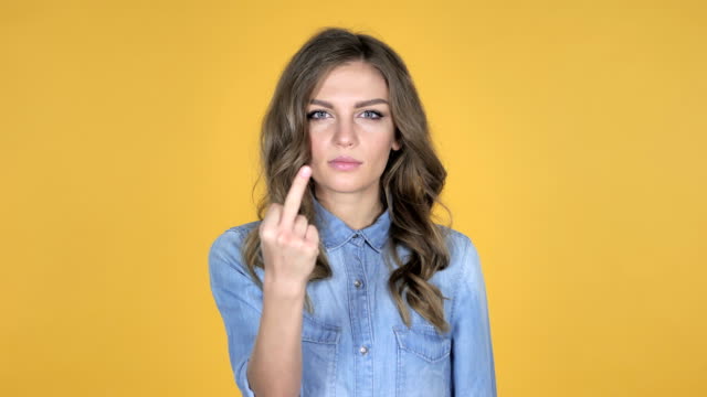 Young-Girl-Showing-Middle-Finger-Isolated-on-Yellow-Background