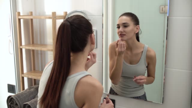 Make-up.-Frau,-die-Anwendung-flüssiger-Lippenstift-auf-die-Lippen-auf-Bad