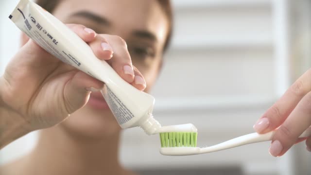 Teeth-Hygiene.-Woman-Applying-Toothpaste-On-Toothbrush-Closeup