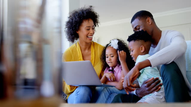 Vorderansicht-der-Familie-black-mit-Laptop-im-Wohnzimmer-zu-Hause-4k