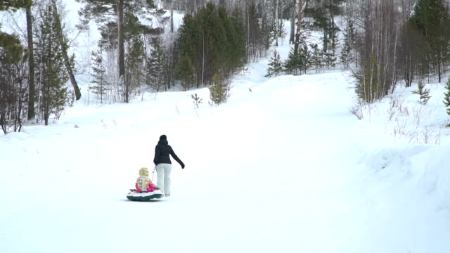 Mother-and-Daughter-Pulling-a-Snow-Tube-to-a-Hill