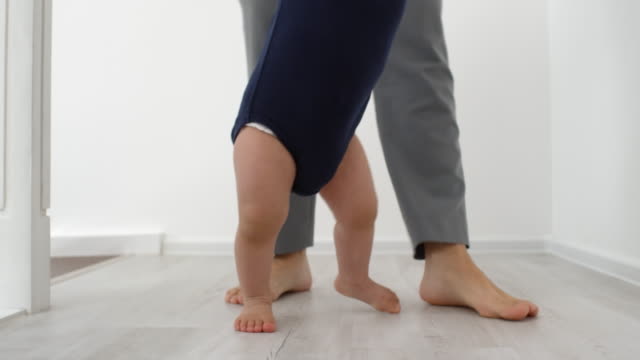 Barefoot-Toddler-Learning-to-Walk-with-Support