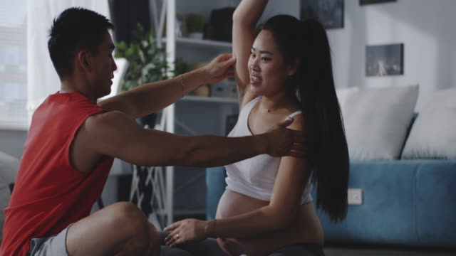 Young-man-instructing-pregnant-woman-during-workout