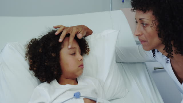 Vista-frontal-de-la-madre-afroamericana-hablando-con-su-hijo-en-el-pabellón-en-el-hospital-4k