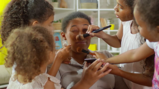 Girls-Applying-Makeup-on-Mother’s-Face