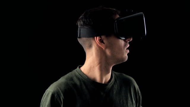Porträt-des-jungen-Mannes-mit-VR-Brille-auf-schwarzem-Hintergrund.-Männliche-Virtual-Reality-Konsole-Headset-Play-3D-Gaming-Innovation-Internet-Entertainment-Technologie