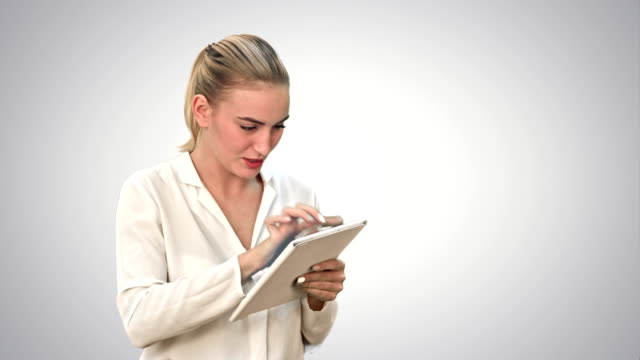 Businesswoman-standing-with-digital-tablet,-touching-the-screen-and-smiling-on-white-background