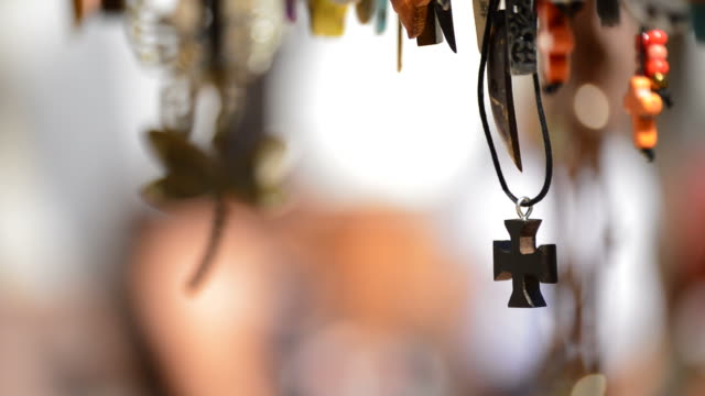 Wooden-cross-in-leather-necklace-hanging-in-a-display