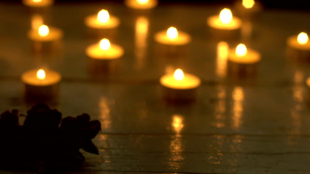 Romantische-Kerzen-brennen-mit-Rosenblüte-auf-weißem-Holz-Schreibtisch