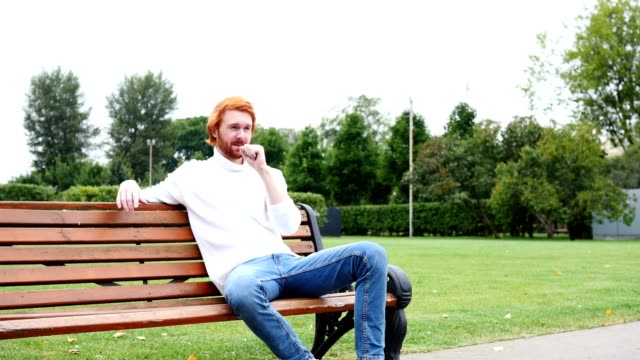 Kranker-Mann-Husten,-sitzen-im-Park,-rote-Haare-und-Bart
