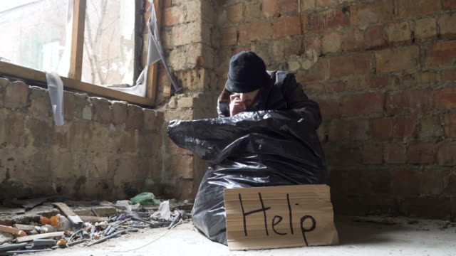 Obdachloser-finden-eine-Zigarette-in-Müllsack