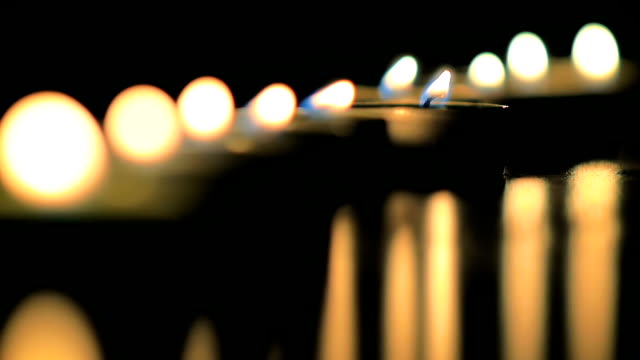 Close-up-of-a-abstract-a-lot-of-a-little-wax-candles-slowly-burning-in-slow-motion.