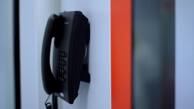 Dialing-telephone-on-white-wall-with-orange-line.-Communication-technology