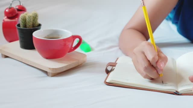 Frau-Hand-mit-Stift-schreiben-Notebook-auf-bedroom.4k-Filmmaterial-mit-Dolly-Schuss
