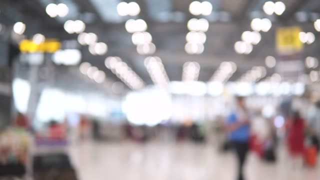 Unscharfe-Aufnahmen-von-Passagieren-im-internationalen-Flughafen-terminal-zu-Fuß.-4K-Video-mit-defokussierten-Wirkung.