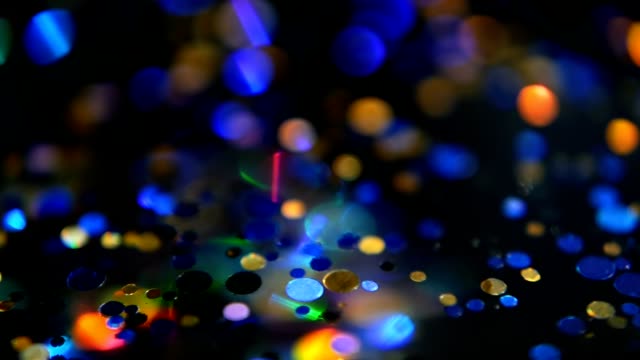 Defocused-shimmering-multicolored-glitter-confetti,-black-background.-Holiday-abstract-festive-bokeh-light-spots.