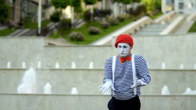 Lustige-Mime-in-roten-Baskenmütze-Klavierspiel-im-Brunnen-Hintergrund