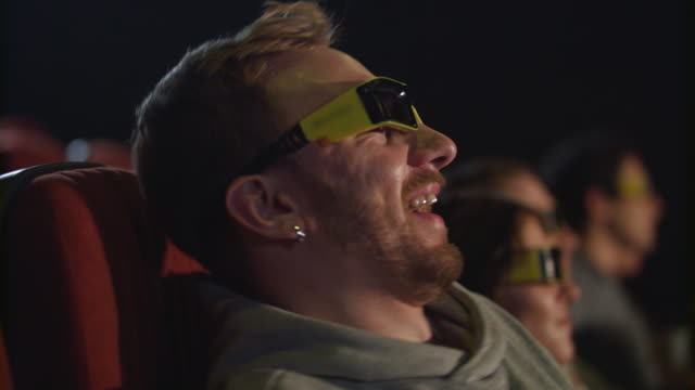 Mann-nehmen-Film-Brille-im-Kino-in-Zeitlupe-ab.-Müde-vom-3D-Film