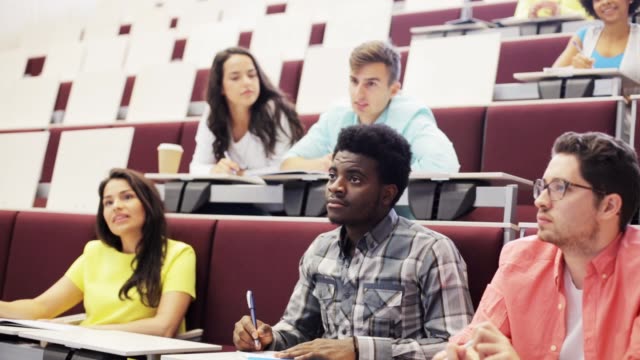 group-of-students-with-notebooks-in-lecture-hall