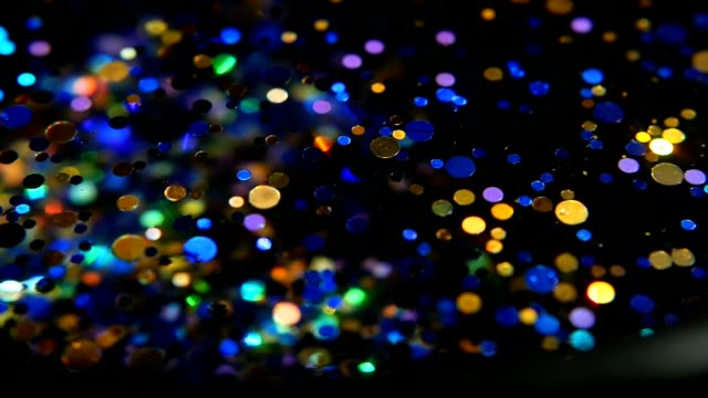 Defocused-shimmering-multicolored-glitter-confetti,-black-background.-Party,-magic,-imagination.-Rainbow-colors,-sparkle-circles.-Holiday-abstract-festive-texture-of-shiny-blurred-bokeh-light-spots.