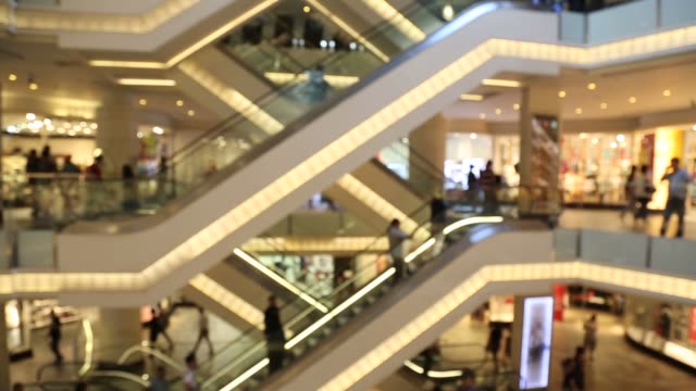 People-Using-Escalator-In-Shopping-Mall-Centre